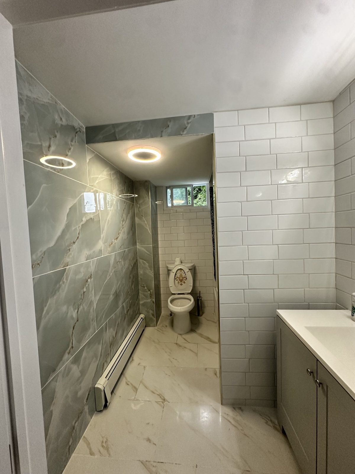 Finished bathroom remodel with marble-look tile