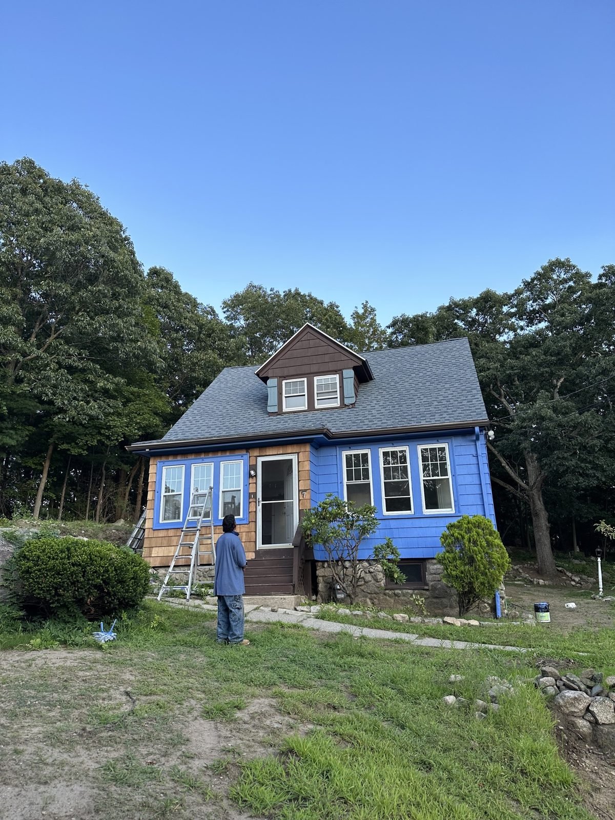 Exterior painting in progress — blue paint going on